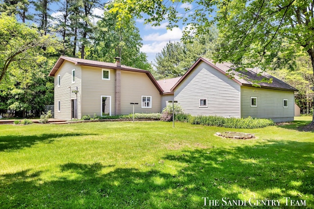 7120 Quarterline Rd, Spring Lake, MI 49456 - back of house with a lawn and a chimney