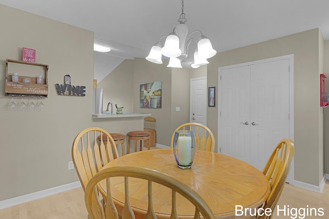 614 Oriole Ct Unit 7, Middleville, MI 49333 - dining area with baseboards, light wood-style floors, and a chandelier