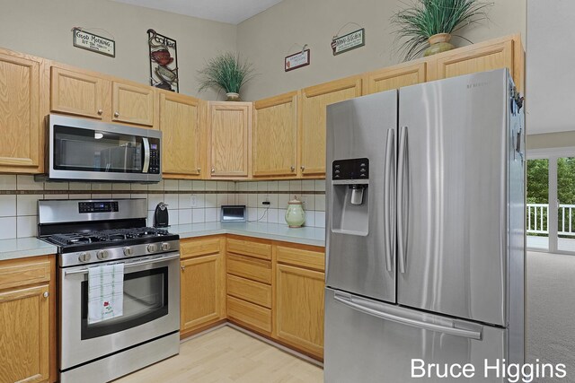614 Oriole Ct Unit 7, Middleville, MI 49333 - kitchen with appliances with stainless steel finishes, light countertops, backsplash, light brown cabinetry, and light wood-style flooring