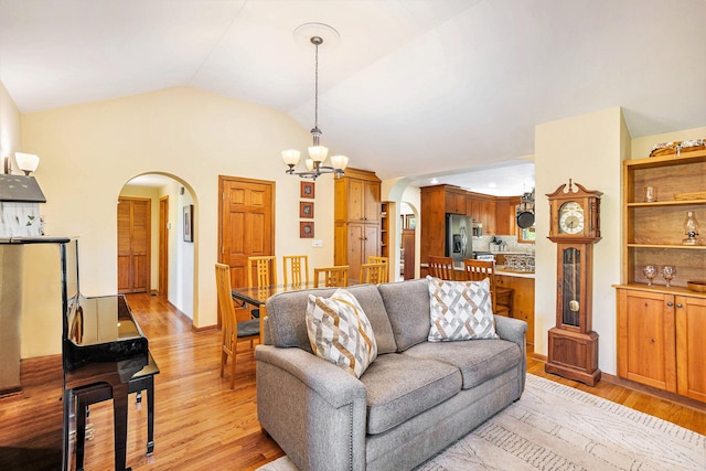 5700 Dexter Townhall Rd, Dexter, MI 48130 - living area featuring arched walkways, a chandelier, light wood-type flooring, and lofted ceiling
