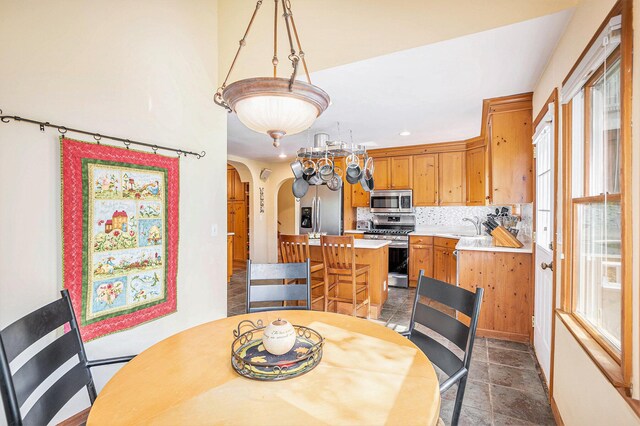 5700 Dexter Townhall Rd, Dexter, MI 48130 - dining area featuring arched walkways, recessed lighting, and dark stone finish flooring