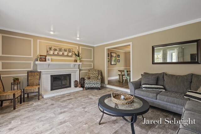 6872 Forest Valley Dr SE, Grand Rapids, MI 49546 - living room featuring crown molding, wood finished floors, a brick fireplace, and baseboards