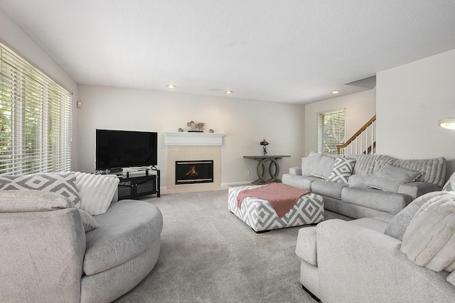 5448 Waterfield Ct, Ann Arbor, MI 48108 - carpeted living room featuring recessed lighting, a tiled fireplace, and stairs