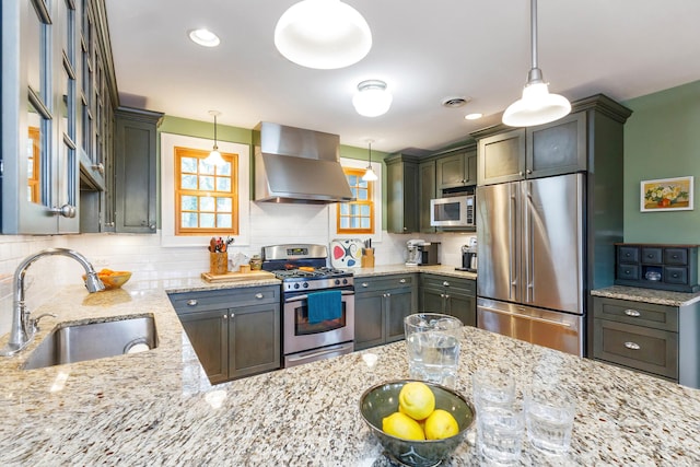16434 S Basswood Rd, Three Oaks, MI 49128 - kitchen featuring appliances with stainless steel finishes, wall chimney range hood, a sink, tasteful backsplash, and light stone countertops
