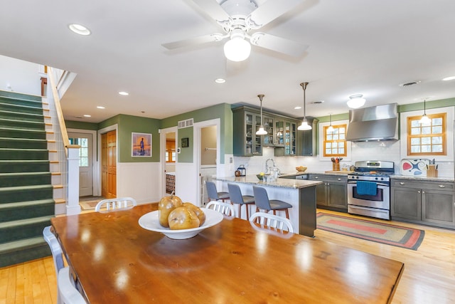 16434 S Basswood Rd, Three Oaks, MI 49128 - dining area with a wainscoted wall, recessed lighting, stairs, light wood-type flooring, and ceiling fan