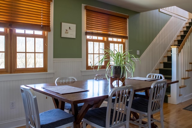 16434 S Basswood Rd, Three Oaks, MI 49128 - dining room featuring stairs, wainscoting, and wood finished floors