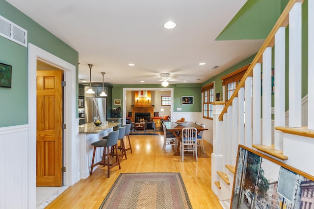 16434 S Basswood Rd, Three Oaks, MI 49128 - dining area featuring stairway, wainscoting, light wood finished floors, recessed lighting, and ceiling fan