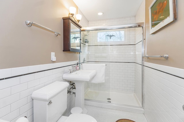 16434 S Basswood Rd, Three Oaks, MI 49128 - bathroom with tile walls, toilet, a shower stall, a wainscoted wall, and tile patterned flooring