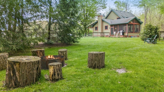16434 S Basswood Rd, Three Oaks, MI 49128 - view of grassy yard featuring a sunroom and a fire pit
