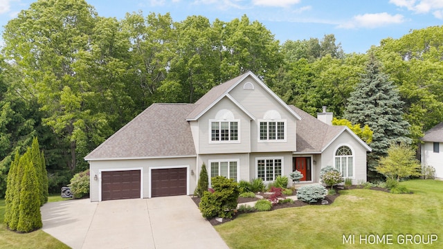 2103 Woodlark Dr, Holland, MI 49424 - view of front of home with concrete driveway, a front yard, a garage, roof with shingles, and a chimney