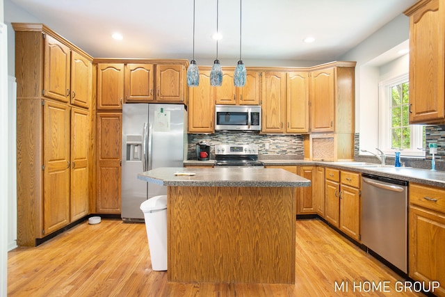 2103 Woodlark Dr, Holland, MI 49424 - kitchen featuring appliances with stainless steel finishes, light wood-type flooring, backsplash, dark countertops, and recessed lighting