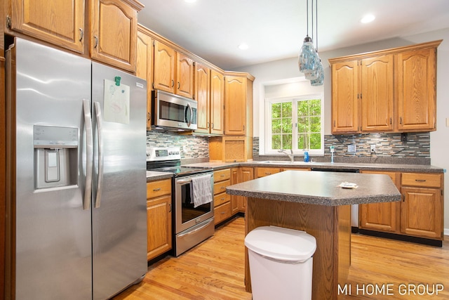 2103 Woodlark Dr, Holland, MI 49424 - kitchen with appliances with stainless steel finishes, dark countertops, light wood-type flooring, a sink, and recessed lighting