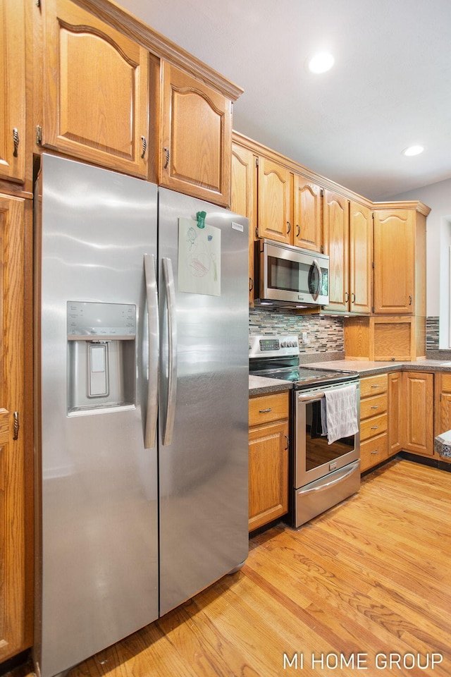 2103 Woodlark Dr, Holland, MI 49424 - kitchen featuring stainless steel appliances, light wood finished floors, backsplash, and recessed lighting