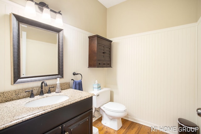 2103 Woodlark Dr, Holland, MI 49424 - half bathroom featuring a wainscoted wall, vanity, toilet, and wood finished floors