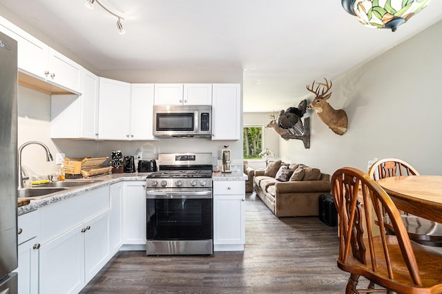 84 Eldred St, Battle Creek, MI 49015 - kitchen featuring appliances with stainless steel finishes, a sink, dark wood-style flooring, and white cabinets
