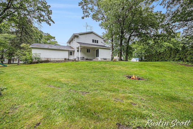 310 Brookgate Ct NW, Comstock Park, MI 49321 - back of house with a fire pit and a lawn