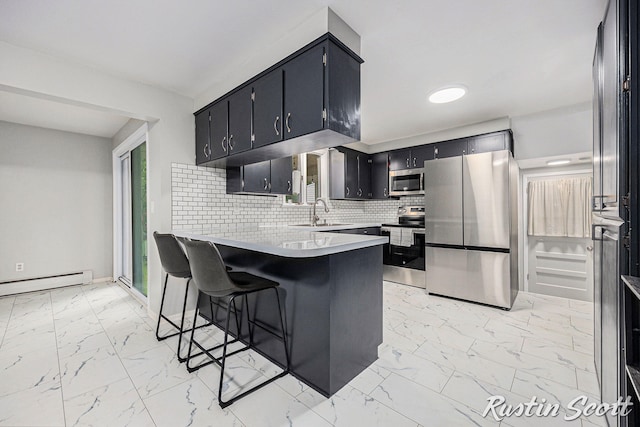 310 Brookgate Ct NW, Comstock Park, MI 49321 - kitchen featuring stainless steel appliances, light marble finish flooring, a peninsula, decorative backsplash, and a baseboard radiator
