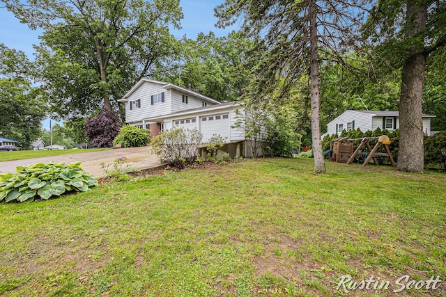 310 Brookgate Ct NW, Comstock Park, MI 49321 - view of grassy yard with concrete driveway and a garage