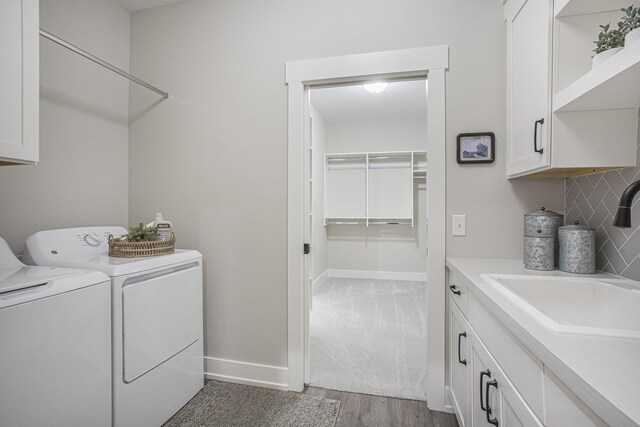 2740 Woodhaven Ct SW Unit 02, Byron Center, MI 49315 - laundry area featuring washer and clothes dryer, cabinet space, wood finished floors, and baseboards