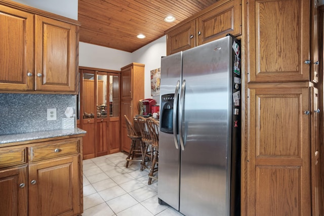 43 W Cherry Ave, Zeeland, MI 49464 - kitchen with stainless steel fridge, brown cabinets, wooden ceiling, and light tile patterned floors