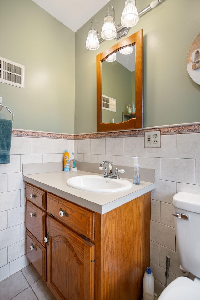 43 W Cherry Ave, Zeeland, MI 49464 - half bath featuring tile walls, vanity, toilet, a wainscoted wall, and tile patterned flooring