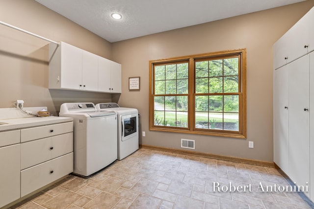 6374 Blakely Dr NE, Rockford, MI 49341 - laundry room featuring cabinet space, separate washer and dryer, baseboards, light stone finish floors, and a textured ceiling