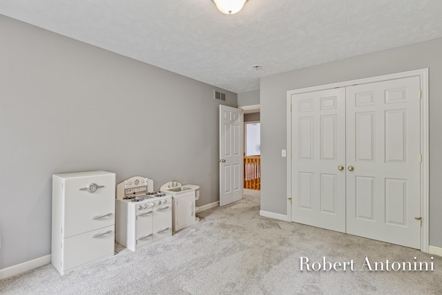 6374 Blakely Dr NE, Rockford, MI 49341 - unfurnished bedroom featuring light colored carpet, baseboards, a closet, and a textured ceiling