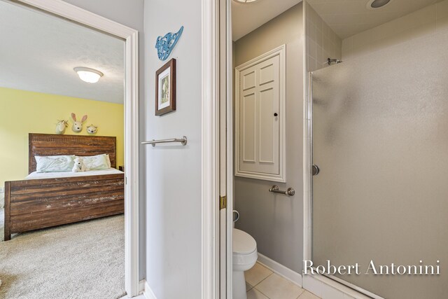 6374 Blakely Dr NE, Rockford, MI 49341 - ensuite bathroom featuring a stall shower, toilet, tile patterned floors, and baseboards