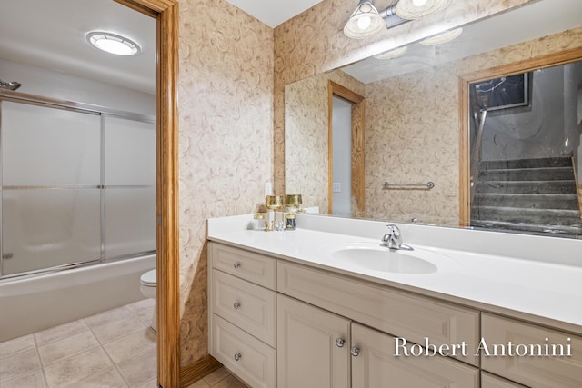 6374 Blakely Dr NE, Rockford, MI 49341 - bathroom featuring vanity, toilet, enclosed tub / shower combo, wallpapered walls, and tile patterned flooring