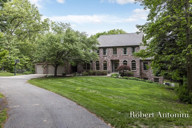 6374 Blakely Dr NE, Rockford, MI 49341 - view of front of home with brick siding, asphalt driveway, and a front lawn