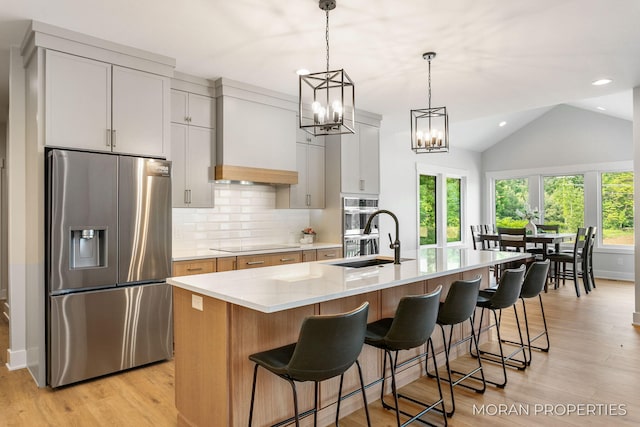 12607 76th Ave, Allendale, MI 49401 - kitchen featuring appliances with stainless steel finishes, tasteful backsplash, a sink, light wood-type flooring, and light countertops