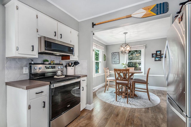 2700 Norfolk Rd SE, Grand Rapids, MI 49506 - kitchen with stainless steel appliances, dark wood-type flooring, crown molding, baseboards, and backsplash