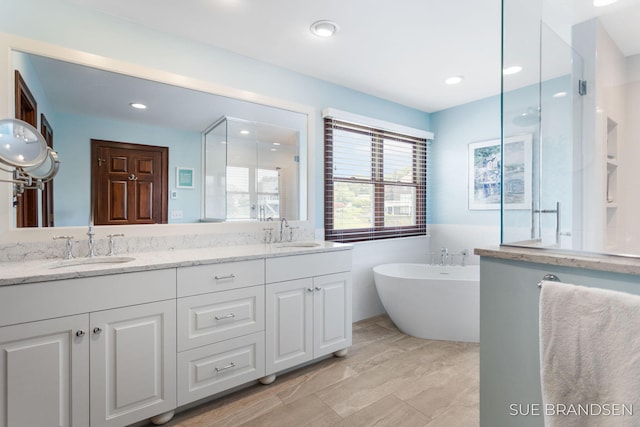 933 Meadow Ridge Dr, Holland, MI 49424 - full bathroom with double vanity, a soaking tub, a shower with door, and recessed lighting