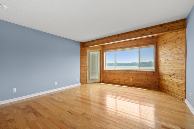125 Wa Wee Nork Dr Unit 109-5-A, Battle Creek, MI 49015 - spare room with wooden walls, light wood-type flooring, and baseboards