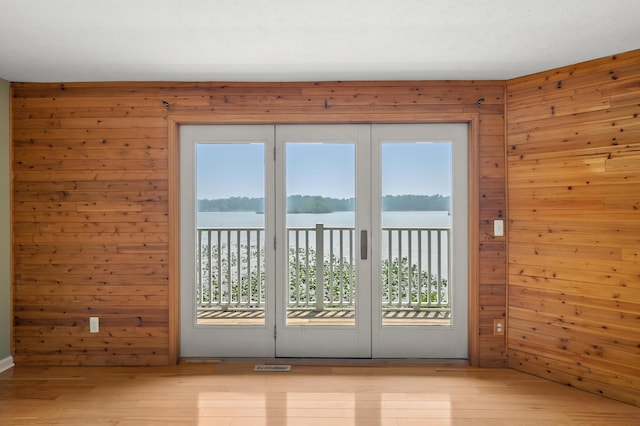125 Wa Wee Nork Dr Unit 109-5-A, Battle Creek, MI 49015 - doorway to outside with wood walls, plenty of natural light, light wood-style flooring, and a water view