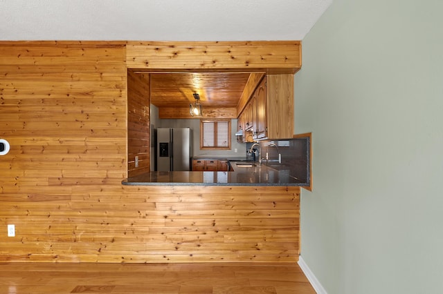 125 Wa Wee Nork Dr Unit 109-5-A, Battle Creek, MI 49015 - kitchen featuring stainless steel fridge with ice dispenser, a sink, baseboards, wood finished floors, and wood walls