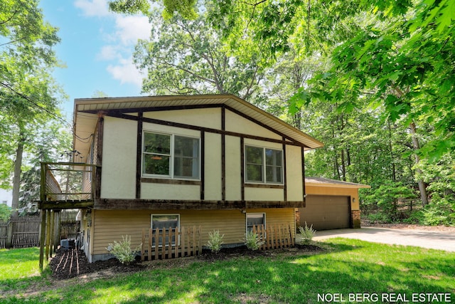 1710 Dykhouse Ave, Grand Haven, MI 49417 - view of front of home with concrete driveway, a garage, central air condition unit, and stucco siding