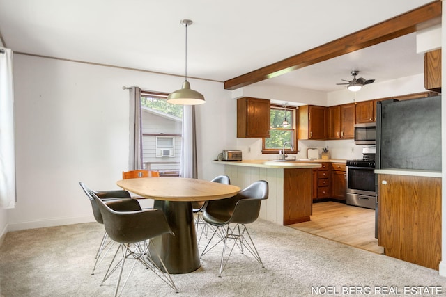 1710 Dykhouse Ave, Grand Haven, MI 49417 - kitchen featuring appliances with stainless steel finishes, light colored carpet, a peninsula, healthy amount of natural light, and beamed ceiling