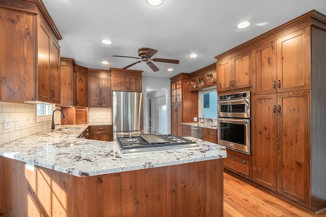 1415 Blackhawk Trl, Benton Harbor, MI 49022 - kitchen featuring appliances with stainless steel finishes, a peninsula, a ceiling fan, recessed lighting, and backsplash