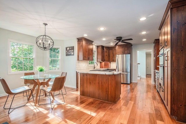 1415 Blackhawk Trl, Benton Harbor, MI 49022 - kitchen with freestanding refrigerator, a chandelier, light wood-style flooring, backsplash, and recessed lighting