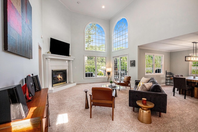 1415 Blackhawk Trl, Benton Harbor, MI 49022 - living area with carpet, crown molding, a glass covered fireplace, a towering ceiling, and a chandelier