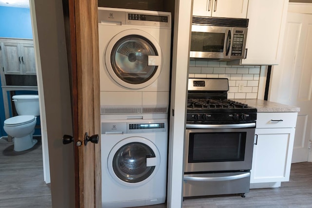 67679 Union Rd, Union, MI 49130 - laundry area with stacked washer and clothes dryer and wood finished floors