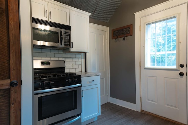 67679 Union Rd, Union, MI 49130 - kitchen featuring stainless steel appliances, decorative backsplash, dark wood-style flooring, lofted ceiling, and white cabinetry
