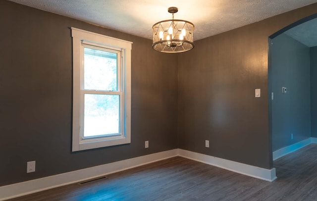 67679 Union Rd, Union, MI 49130 - unfurnished room with arched walkways, a textured ceiling, dark wood finished floors, baseboards, and a chandelier