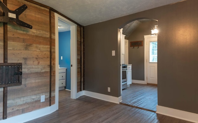 67679 Union Rd, Union, MI 49130 - unfurnished room featuring arched walkways, dark wood finished floors, baseboards, and a textured ceiling