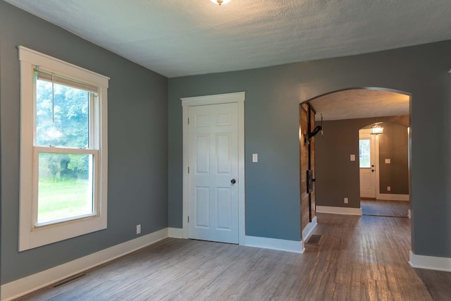 67679 Union Rd, Union, MI 49130 - spare room with arched walkways, wood finished floors, baseboards, and a textured ceiling