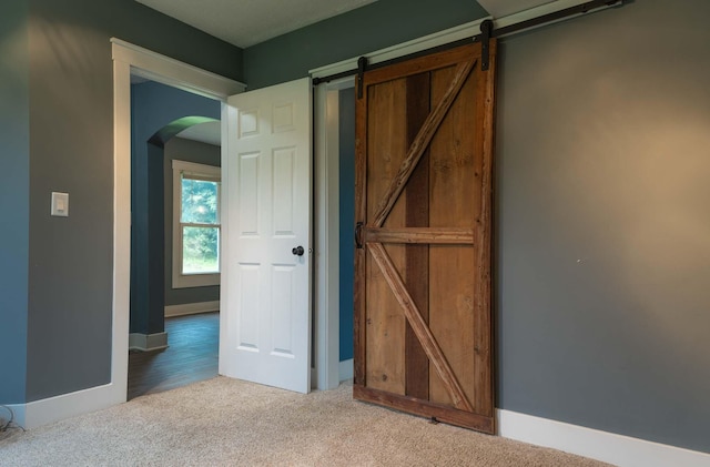 67679 Union Rd, Union, MI 49130 - interior space featuring arched walkways, carpet flooring, baseboards, and a barn door