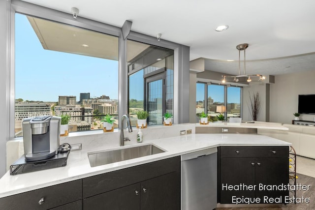 335 Bridge St NW Unit 1101, Grand Rapids, MI 49504 - kitchen featuring a sink, dishwasher, open floor plan, and dark cabinetry