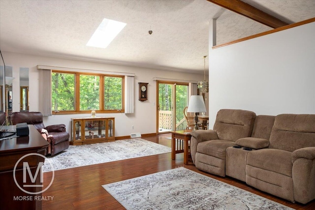 9057 Vergennes St SE, Ada, MI 49301 - living area featuring wood finished floors, a skylight, a textured ceiling, and baseboards