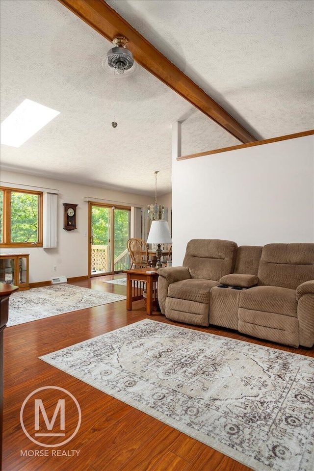 9057 Vergennes St SE, Ada, MI 49301 - living room with a textured ceiling, a skylight, wood finished floors, and baseboards
